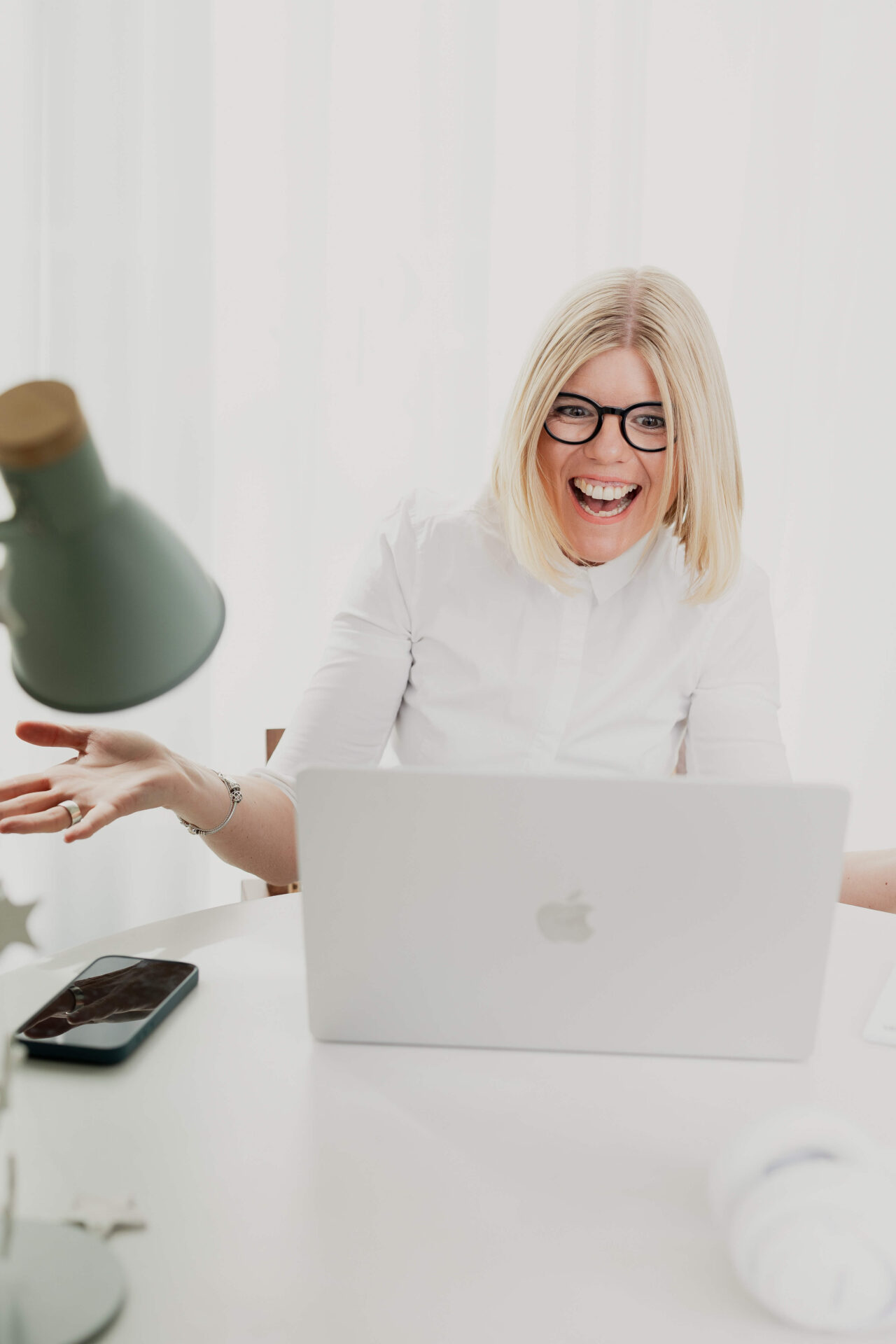Marion Baur, Technik-Expertin und virtuelle Assistentin, sitzt lächelnd auf einer Treppe